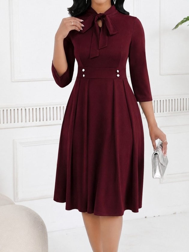 Women's Burgundy Crepe Dress with Bow Neckline and Pleated Skirt - Janes - by Peralane